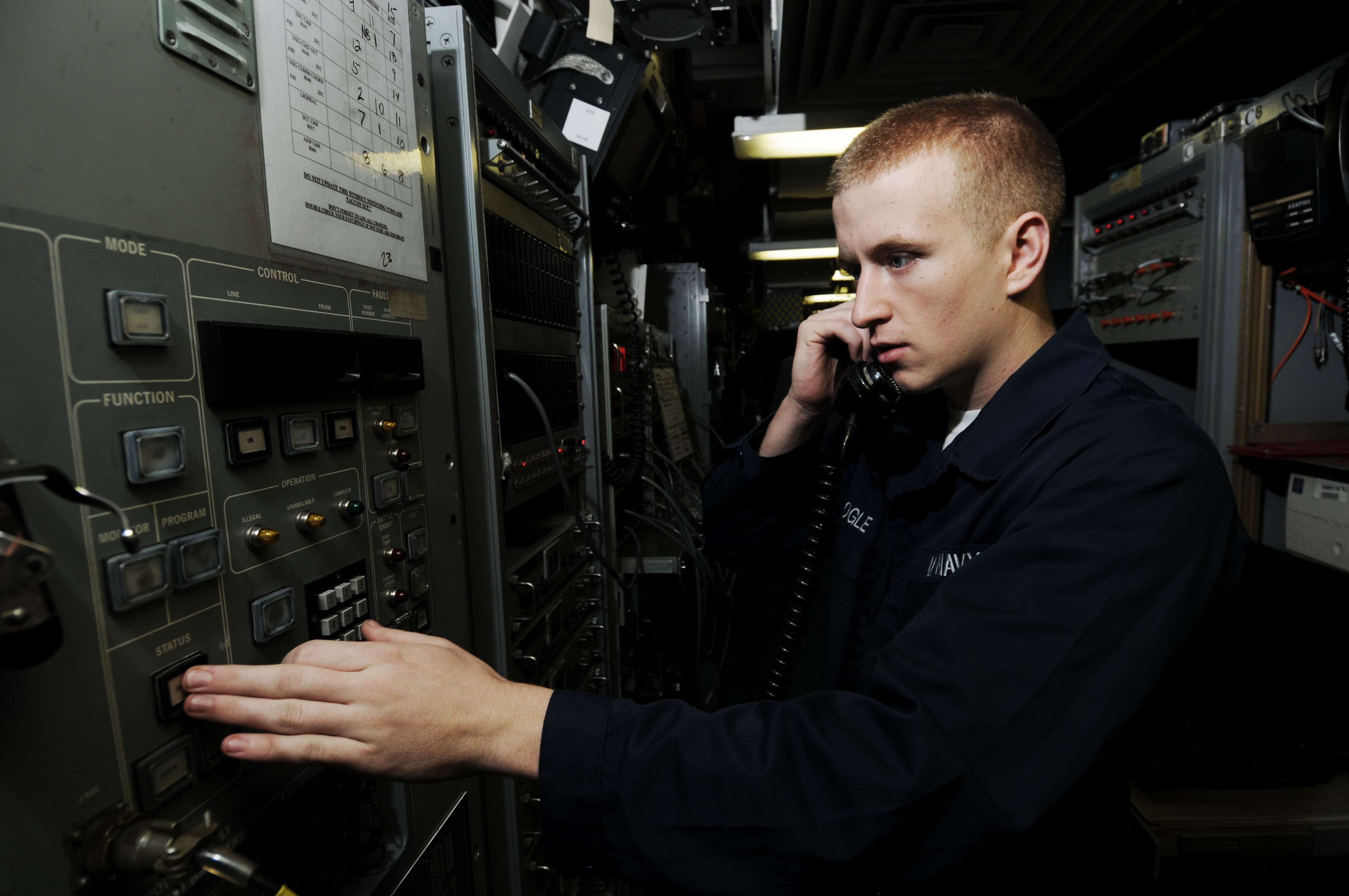 US Navy 091021-N-3038W-016 Information Systems Technician Seaman Dwight Ogle inspects the black audio switch in the combat systems message center