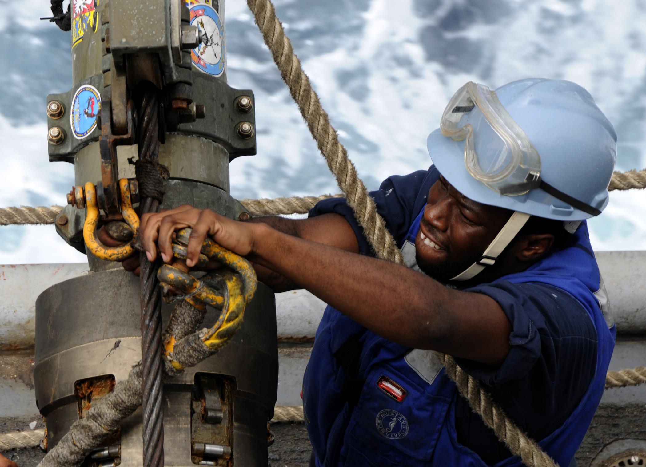 US Navy 100324-N-7948C-235 Aviation Ordnanceman Airman Raymond Thomas unhooks a span line from a re-fueling hose during an underway replenishment