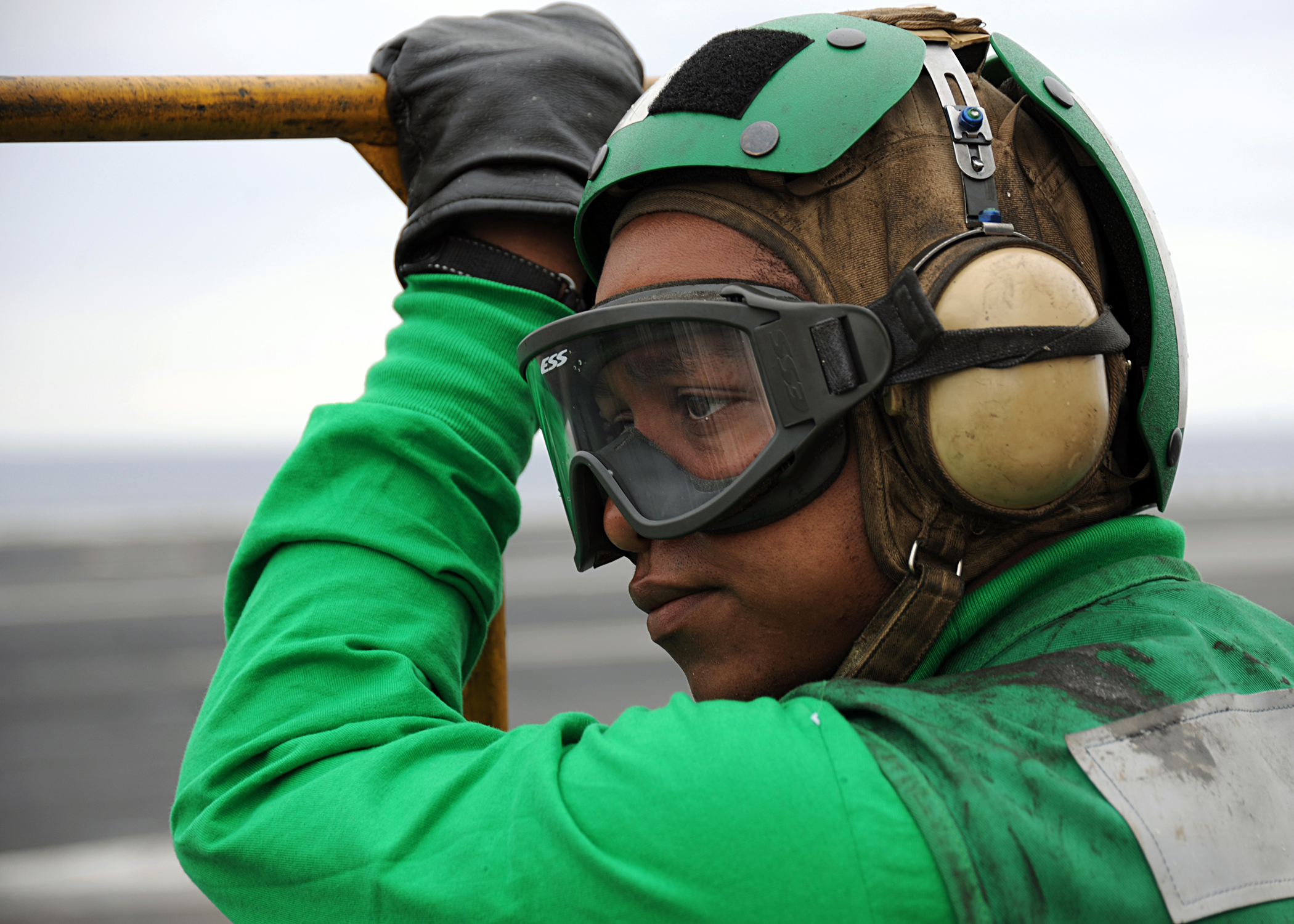 US Navy 100421-N-3885H-153 Aviation Boatswain's Mate (Equipment) Airman Andricio Stinson waits for an aircraft to land aboard the aircraft carrier USS George H.W. Bush (CVN 77)