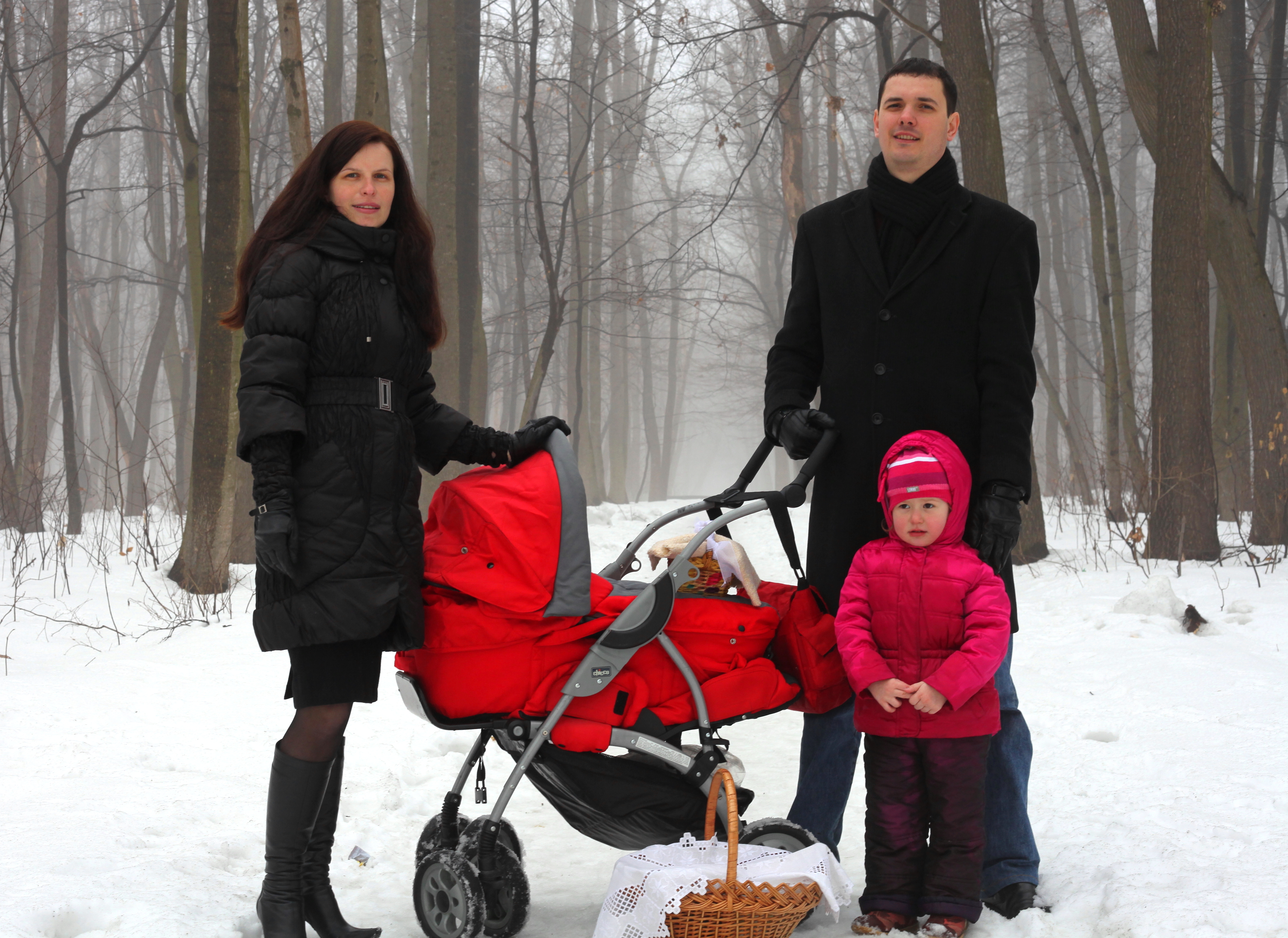 a beautiful Catholic family in a foggy and snowy forest