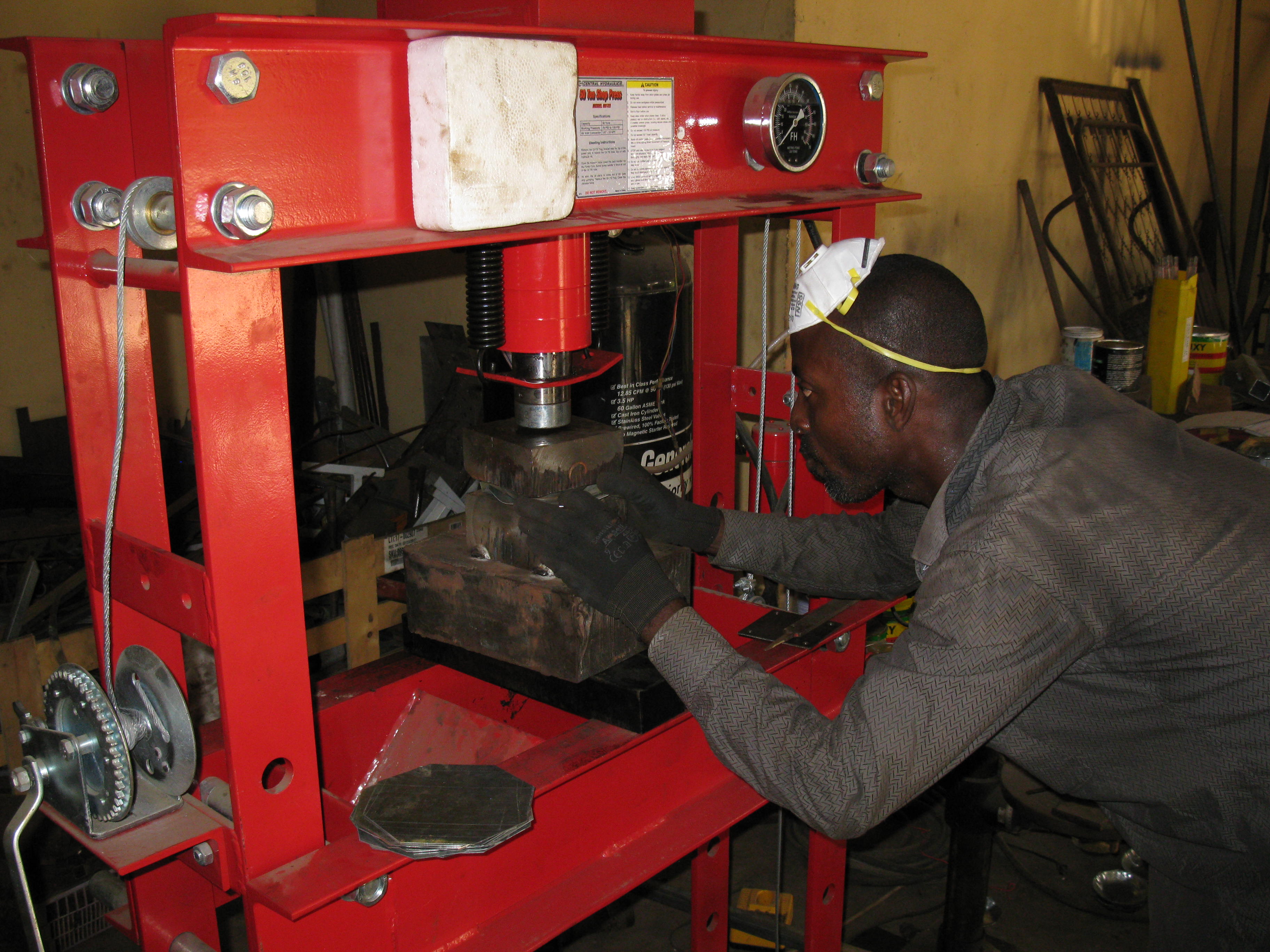 A Ghanaian Metal Fabricator molding a plate