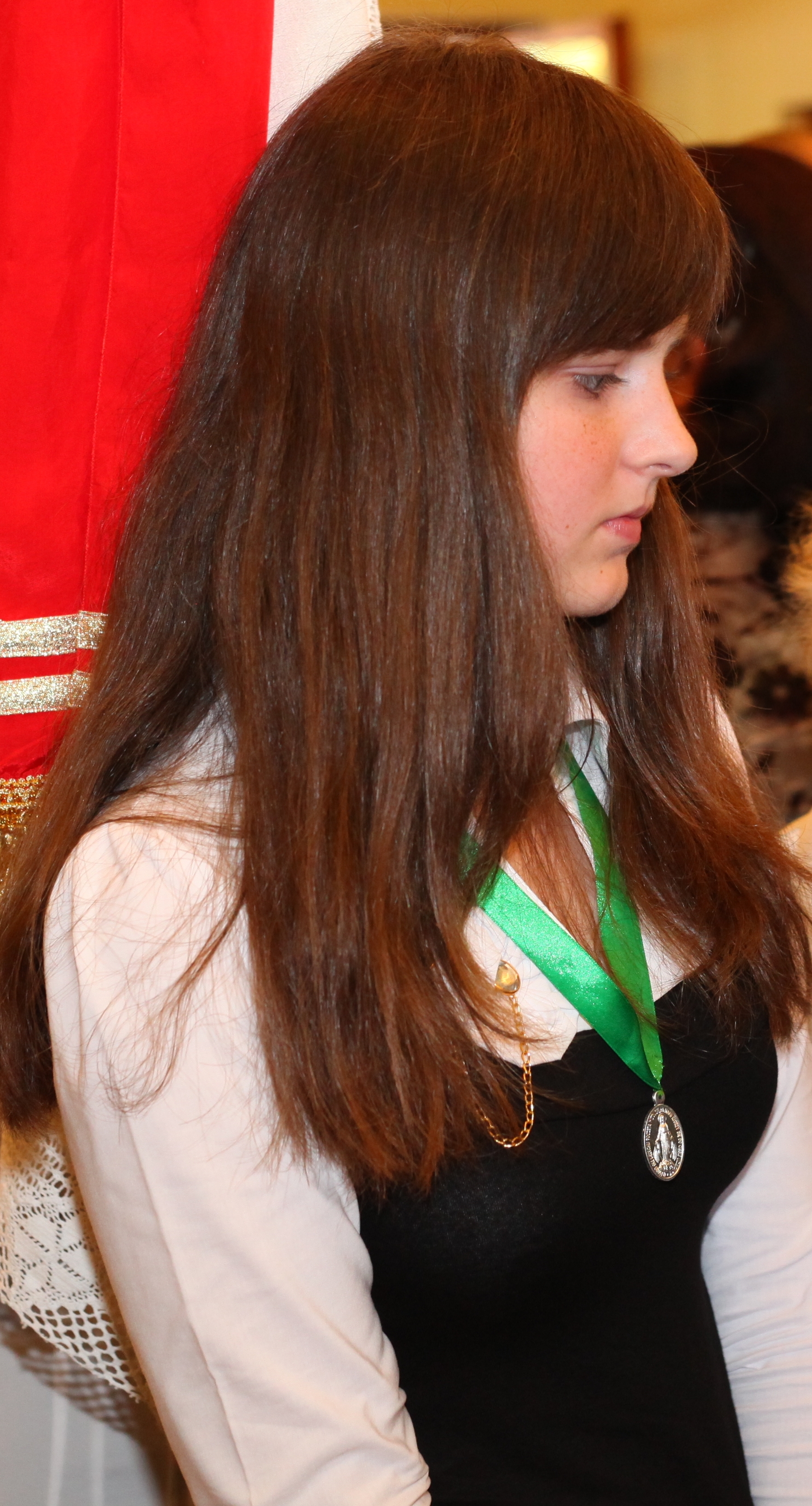 a young brunette Catholic girl at a Holy Mass