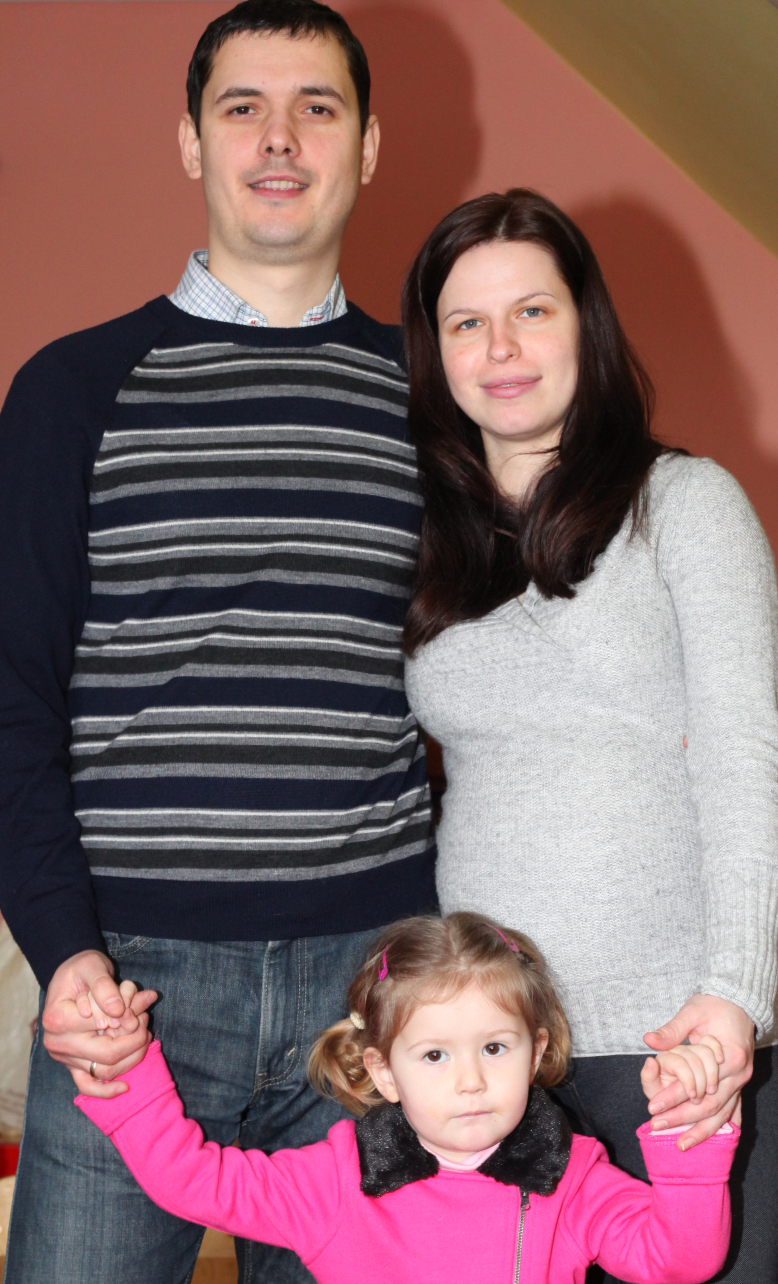 a pregnant beautiful brunette Catholic woman with her husband and daughter, picture 1
