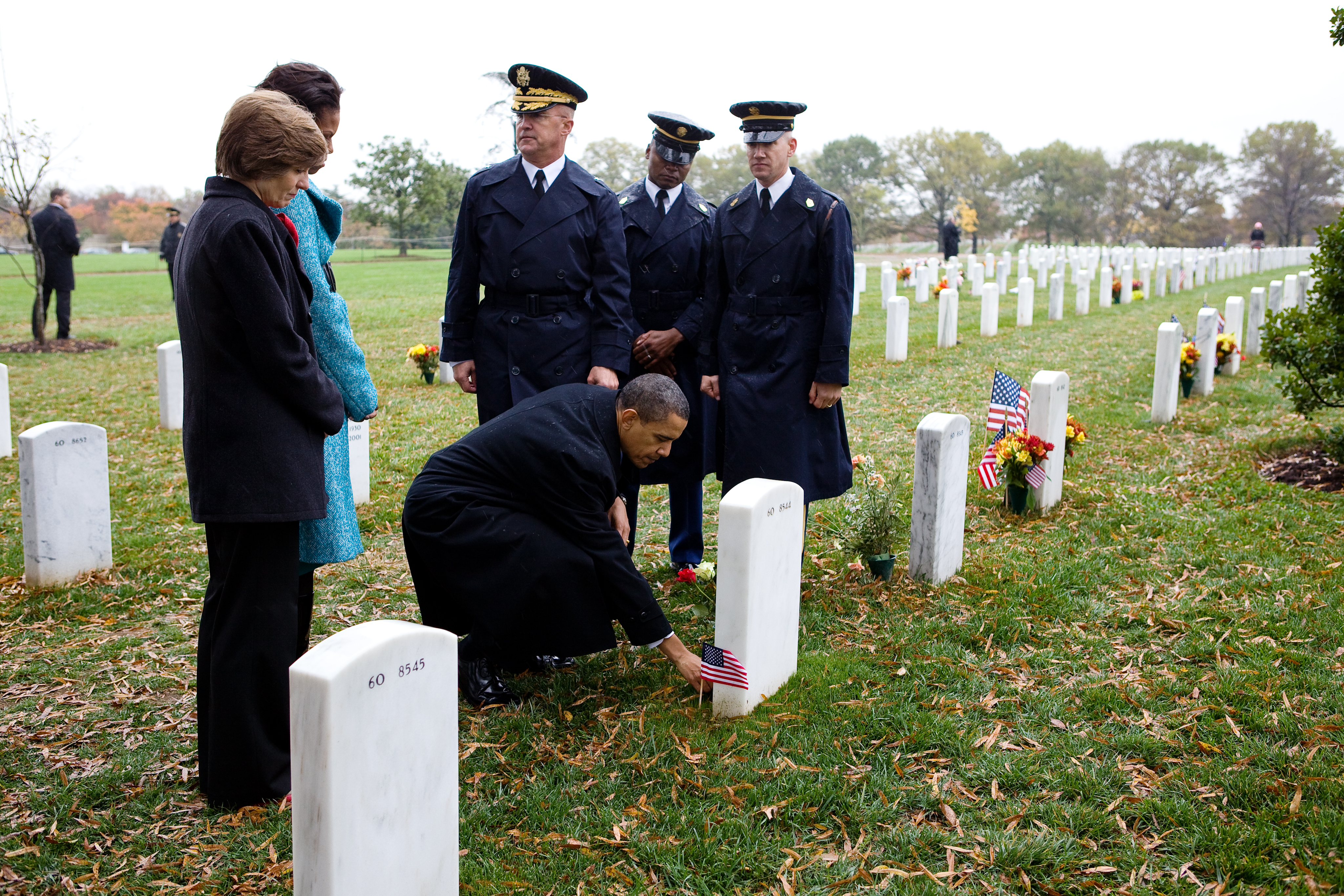 Barack Obama leaves a presidential coin at the gravesite of Ross McGinnis at Arlington Cemetery