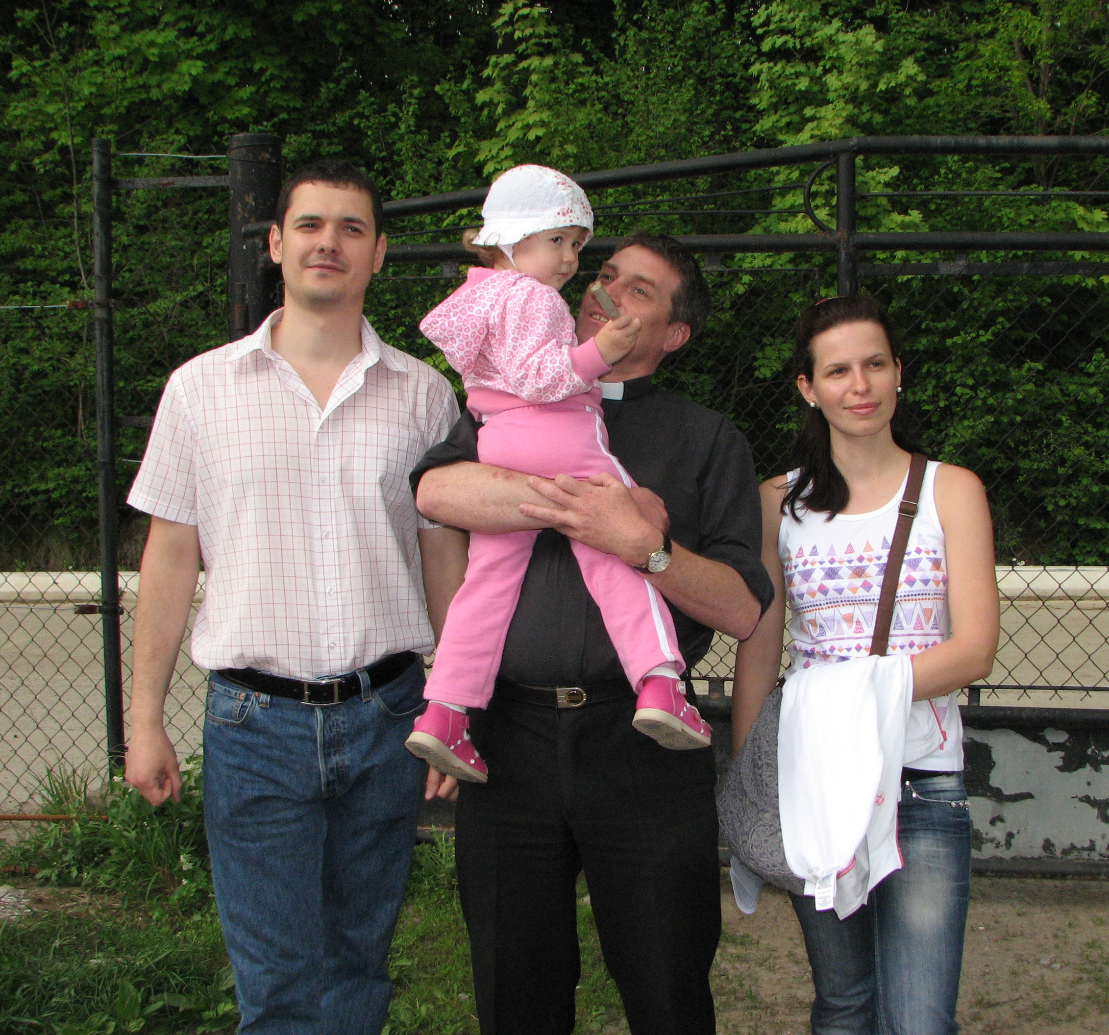 A Catholic priest (in the middle) with a young family, pic 1