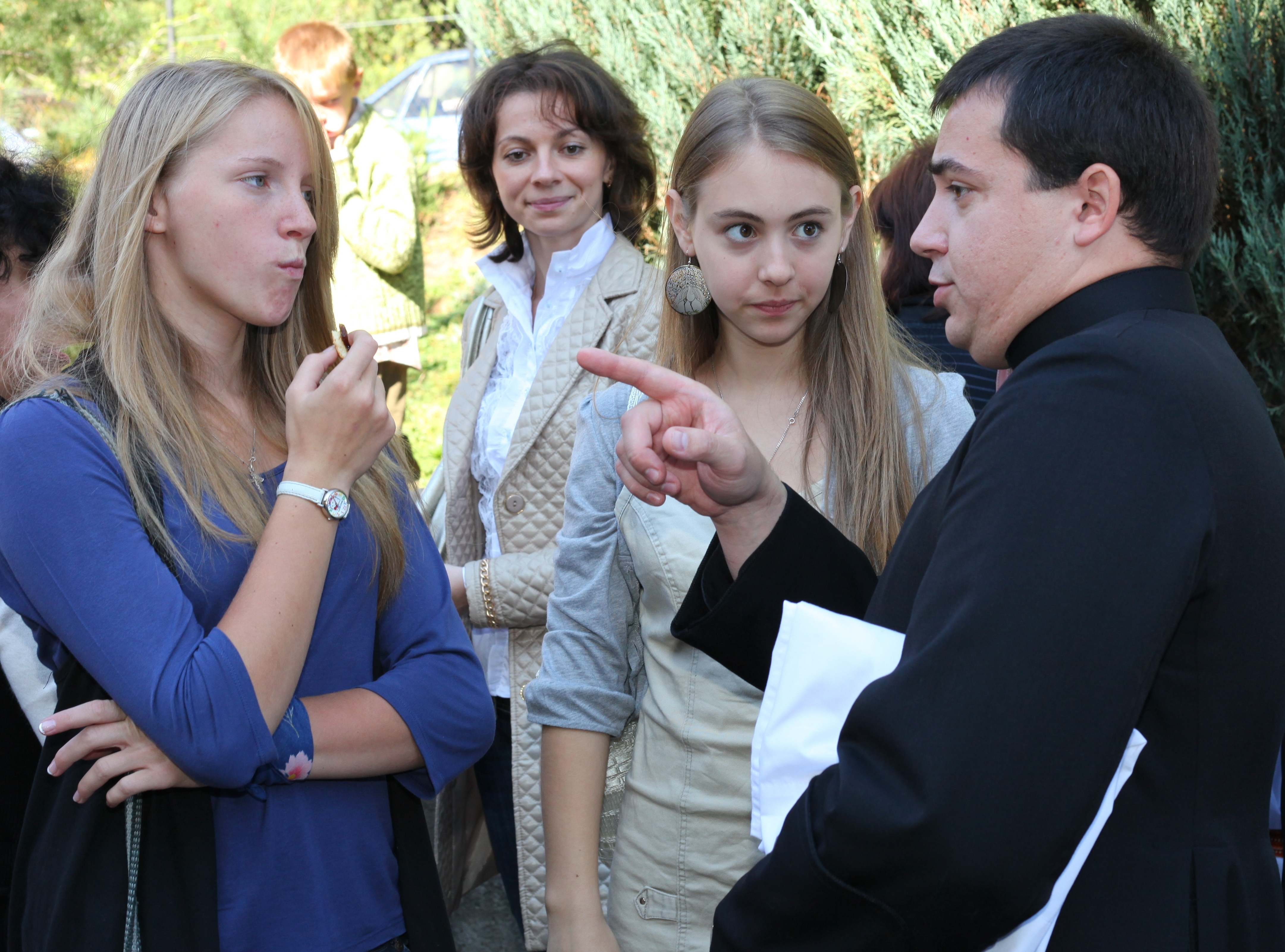 girls and a priest near a Catholic Church after the Holy Mass
