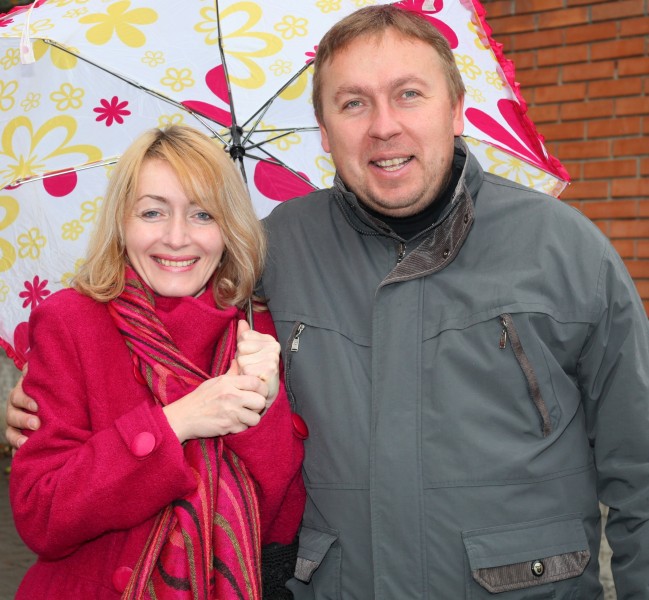 a charming beautiful Catholic woman with an umbrella and a handsome Catholic man