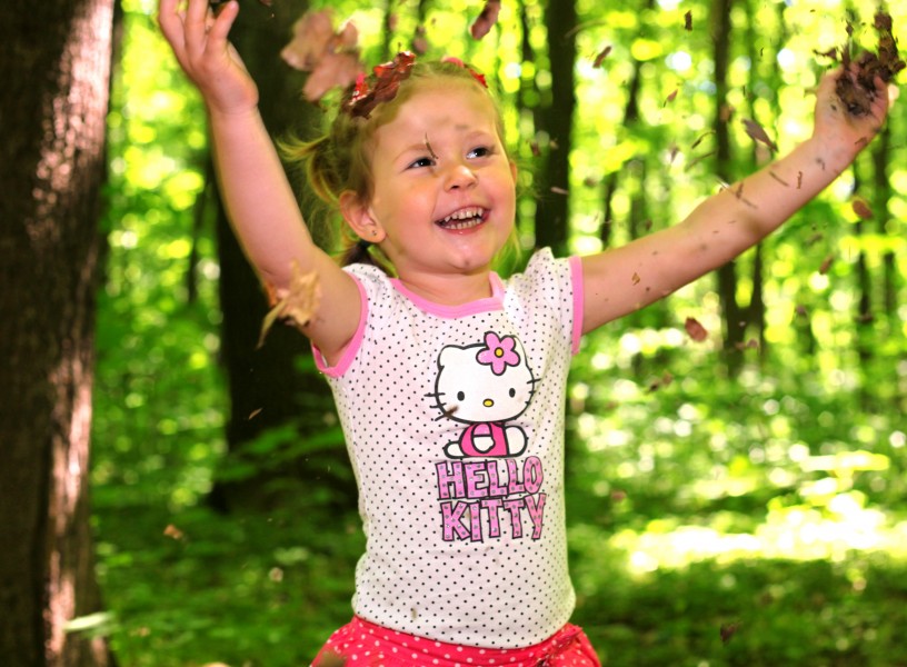 a cute Catholic kid girl in a forest photographed in May 2013, image 1/2