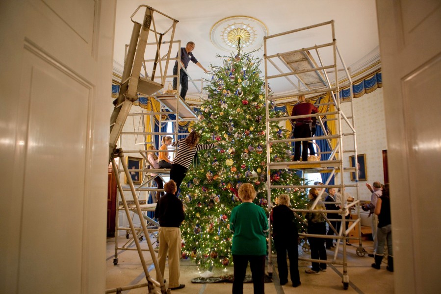 A team of volunteers decorates the official White House Christmas Tree in the Blue Room of the White House