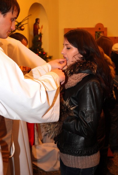 a young beautiful brunette woman taking Jesus in the Holy Communion