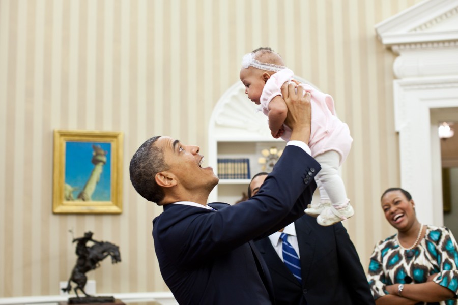 Barack Obama holds up four-month-old Alia Jawando, 2011