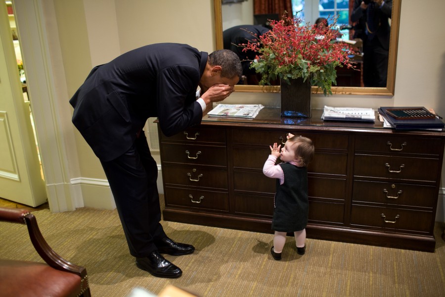 Barack Obama plays peek-a-boo with the daughter of White House staffer Emmett Beliveau, 2009