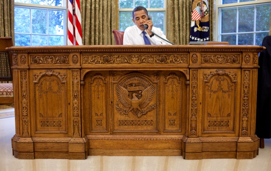 Barack Obama sitting at the Resolute desk 2009