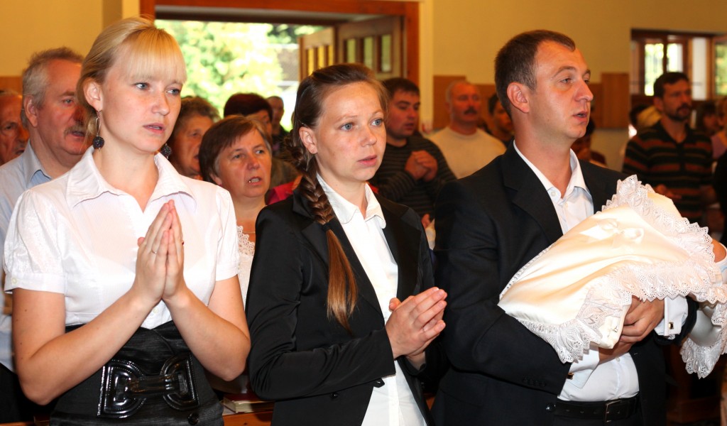 godmother and parents praying during the baptism of the baby-boy in the Catholic Church, photo 8