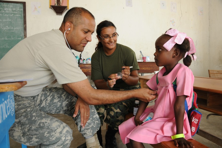 Defense.gov News Photo 100430-A-1526R-164 - U.S. Army Maj. Jose Rivera a doctor with the 94th Combat Support Hospital left works alongside a Uruguayan Navy nurse to examine a young Haitian