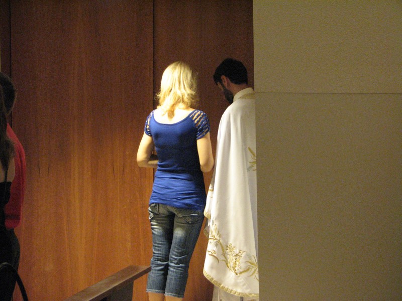 a girl confessing her sins to a Greek-Catholic priest in Fatima, Portugal