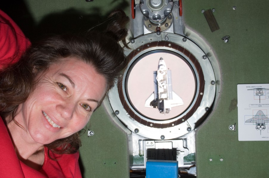 ISS-27 STS-134 Cady Coleman next to a porthole with the Endeavour
