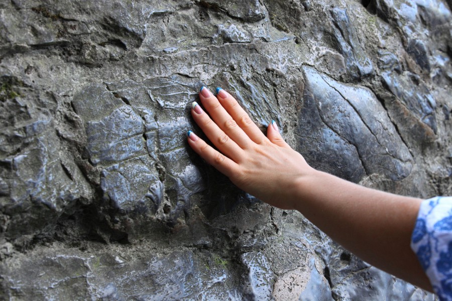 a hand of a girl touching the cave where Our Lady appeared in Lourdes, France, Europe, August 2013, picture 19