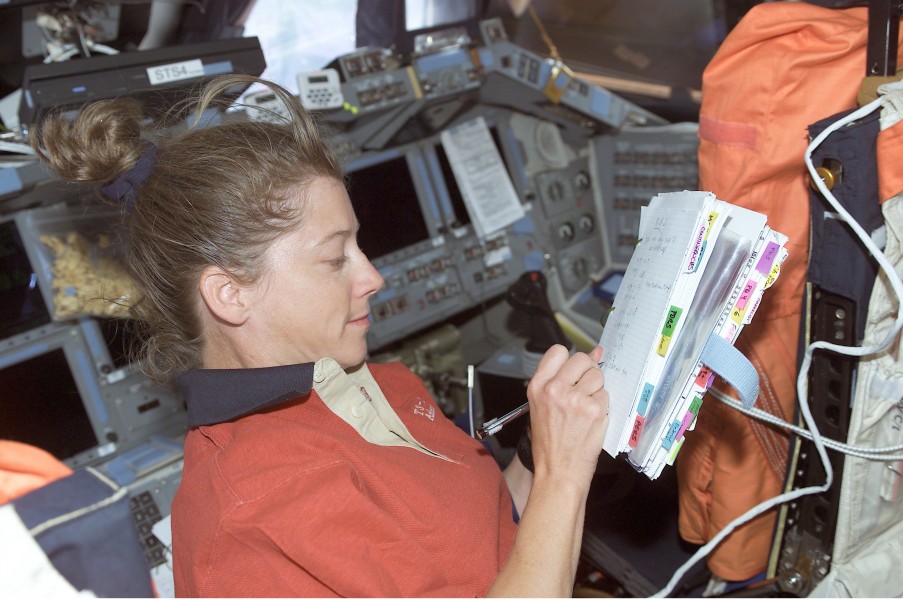 S112 Pamela Melroy works on the flight deck of Atlantis during EVA 1