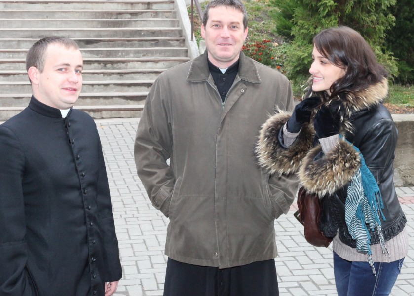 two priests and a beautiful young brunette Catholic woman