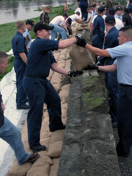 US Navy 031021-N-7711J-010 Volunteers from Naval Air Station (NAS) Whidbey Island, Wash. stack sandbags on a dike as the Skagit River threatens to over run its banks