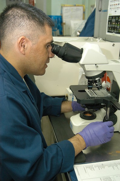 US Navy 040601-N-3986D-033 Hospital Corpsman 2nd Class Carlos Augilar, of Baja, Calif., examines blood cells under a microscope in the Medical Department aboard USS George Washington (CVN 73)