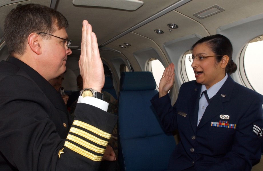 US Navy 050420-N-6997B-002 Commanding Officer, Naval Air Facility Misawa, Capt. Wayne Radloff, reenlists U.S. Air Force Senior Airman Abigail Foster, assigned to the 35th Mission Support Squadron, while flying aboard a C-12 Hur