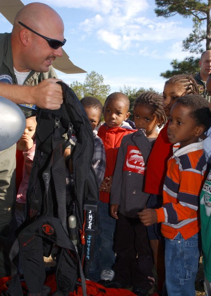 US Navy 061026-N-8544C-049 Chief Aviation Warfare System Operator Jeff Grosos shows students at Woodland Elementary school some of the survival gear found inside the SH-60B Seahawk