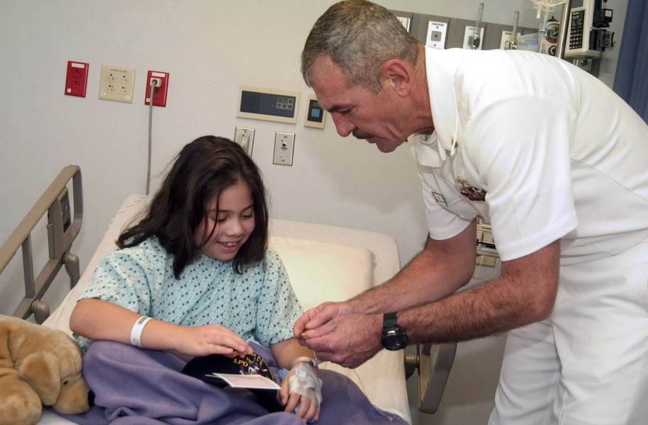 US Navy 061108-N-3750S-140 Chief Master-at-Arms Ed Stift shares coins and talks with a young girl at Methodist Children's Hospital