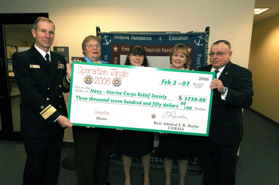US Navy 070202-N-5758H-002 Commander, Navy Region Mid-Atlantic (CNRMA) Rear Adm. Rick Ruehe, presents a $3,750 check from the proceeds of Operation Jingle