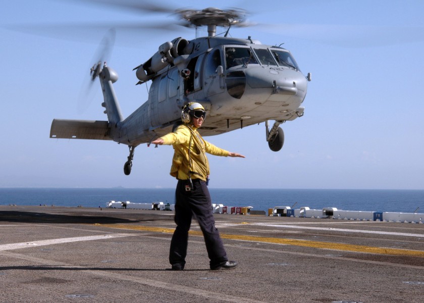 US Navy 070214-N-3211R-017 Aviation Boatswains Mate Handler Airman Noah Timmons stationed aboard the amphibious assault ship USS Bonhomme Richard (LHD 6), gives the clear to launch signal to a MH-60S Seahawk