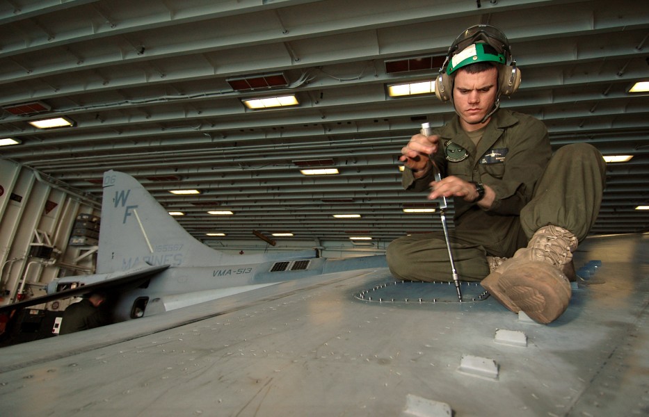 US Navy 070314-N-3211R-019 Lance Cpl. Nathan Redfearn, a native of Herrin, Ill., uses a speeder to remove an access panel on the wing of an AV-8B Harrier, in order to conduct a phase inspection