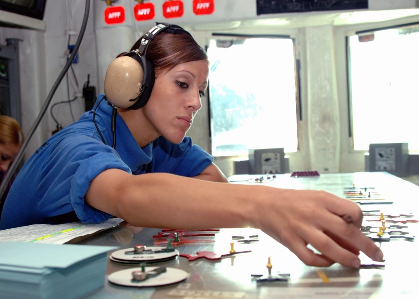 US Navy 071027-N-1287L-063 Aviation Boatswain's Mate (Handling) Airman Sarah McMillen places jet models in their respective positions on a scaled version of the flight deck aboard nuclear-powered aircraft carrier USS Enterprise