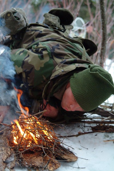 US Navy 080203-N-0411D-036 A student at the Navy Survival, Evasion, Resistance and Escape (SERE) school builds a fire