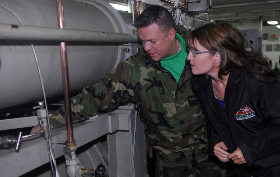 US Navy 090622-N-2475A-050 Alaska Gov. Sarah Palin, right, listens as Aviation Boatswain's Mate (Equipment) 1st Class John Childs, from Fayetteville, N.C., explains the basic components and functions of an arresting gear engine