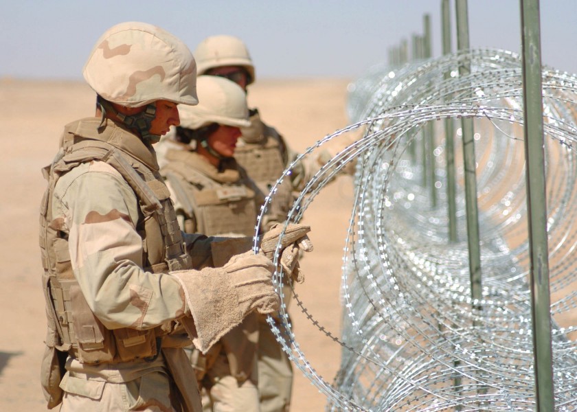 US Navy 090903-N-4440L-246 Seabees assigned to Naval Mobile Construction Battalion (NMCB) 74, install concertina wire during a three-mile expansion of Camp Leatherneck