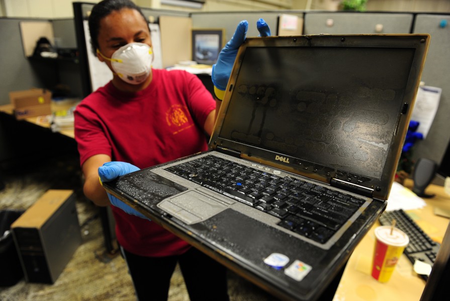 US Navy 100506-N-5862D-002 nformation Systems Technician 1st Class Latarsha Young displays one of many computers that were damaged by floodwaters at the Navy Recruiting Command storage annex