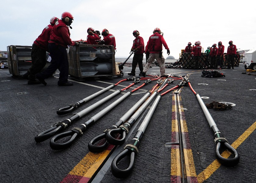 US Navy 100623-N-6720T-001 Aviation ordnanceman arrange munitions pallets before lowering them to the hanger bay of the aircraft carrier USS George Washington (CVN 73)