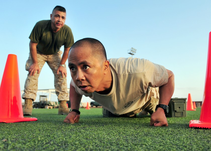 US Navy 110401-N-1755G-208 Chief Personnel Specialist Romel Agliam, right, participates in the Marine Corps Combat Fitness Test in celebration of t