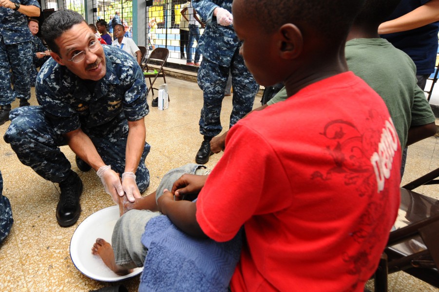 US Navy 110421-F-CF975-233 Capt. Brian Nickerson, mission commander of Continuing Promise 2011, washes the feet of a Harbor View Primary School stu