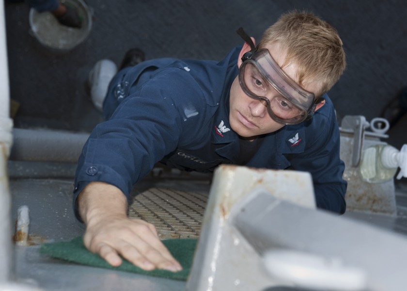 US Navy 110923-N-FI736-047 Hospital Corpsman 3rd Class Logan Ortlieb cleans the bulkhead on the weather decks of the guided-missile destroyer USS A