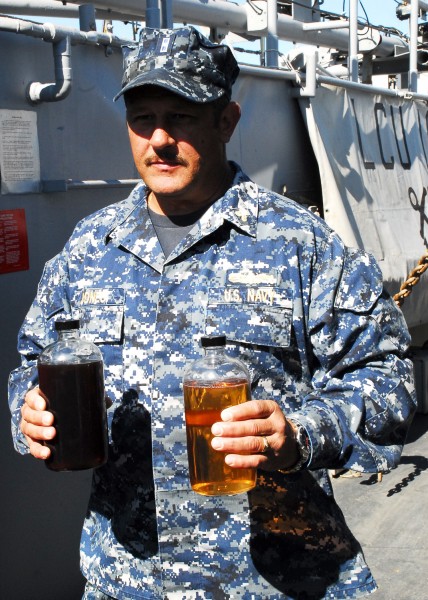 US Navy 111020-N-YT478-006 Chief Warrant Officer 3 Eric Jones, the waterfront maintenance officer for Assault Craft Unit (ACU) 2, holds samples of 