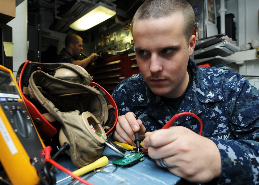 US Navy 120125-N-KQ416-008 Electronics Technician 3rd Class Michael Schranck takes a resistance reading on a circuit card for a flight deck cranial