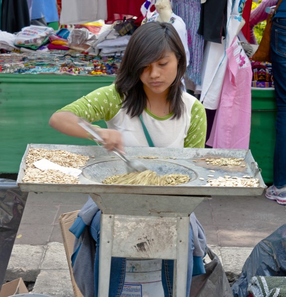 Young woman stirring food at Mexico City street market