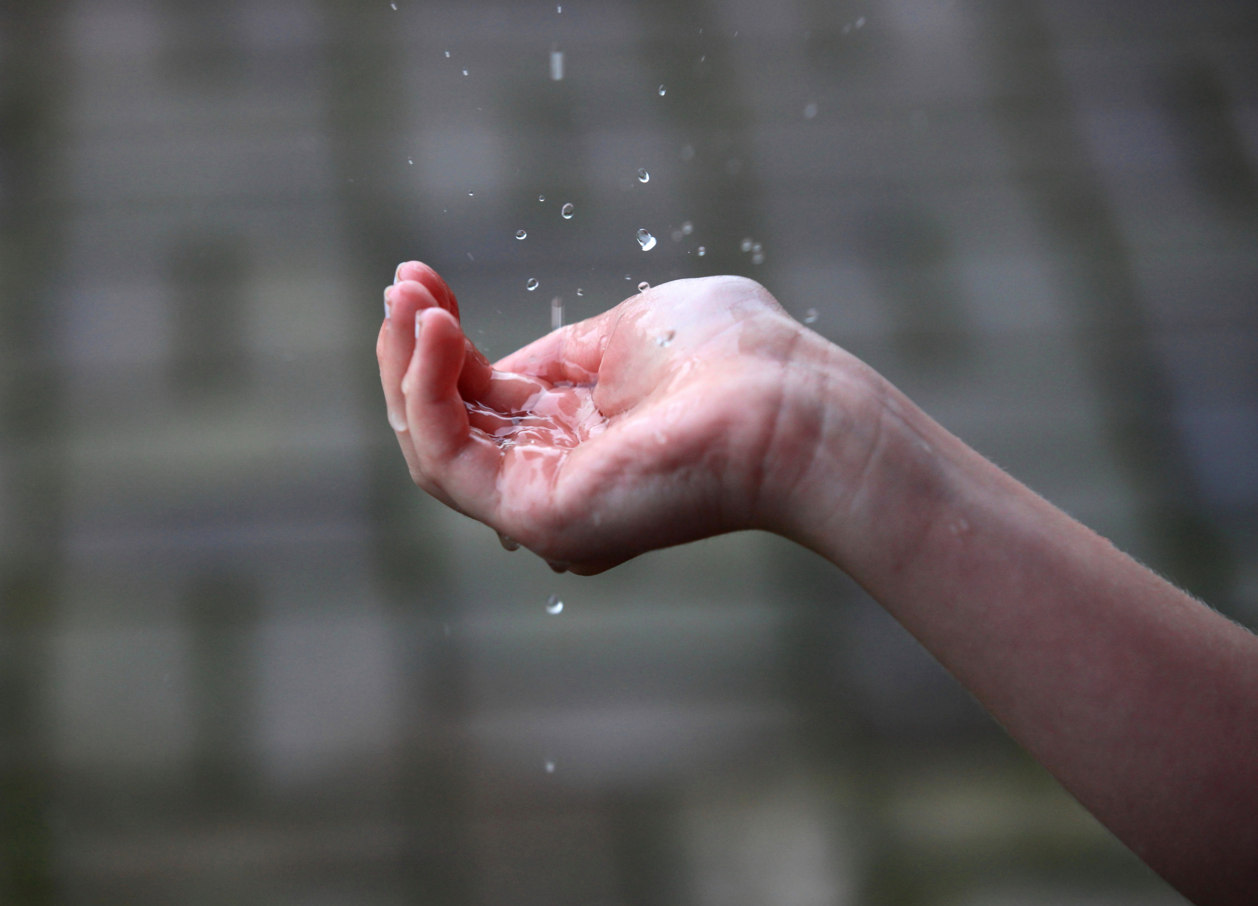 a young girl catching rain water drops with her hand in July 2013