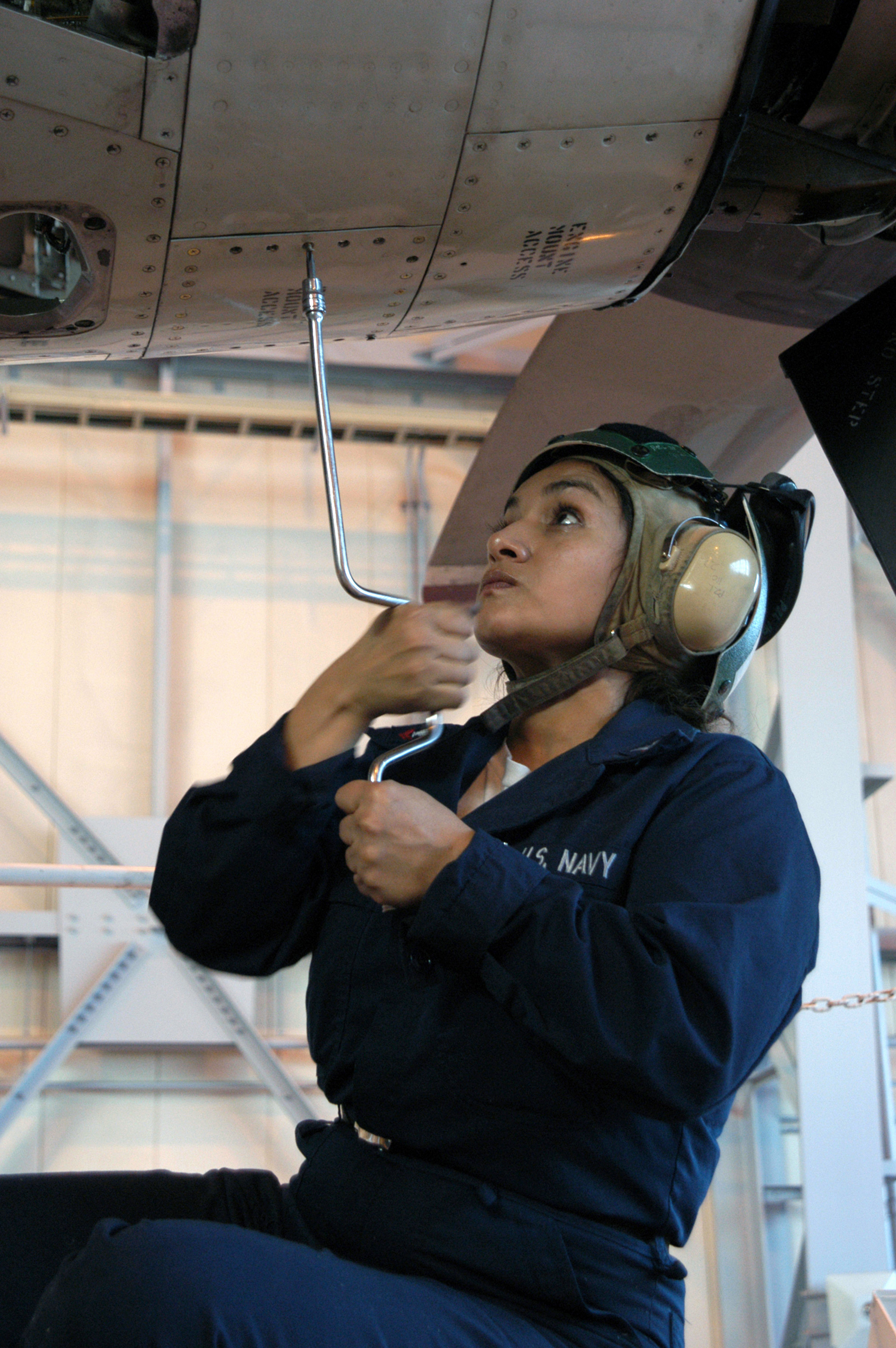 US Navy 030126-N-9760B-004 Aviation Machinist^rsquo,s Mate 2nd Class Roxana Guevara from Irving, Texas, attaches an access panel to the number one engine 