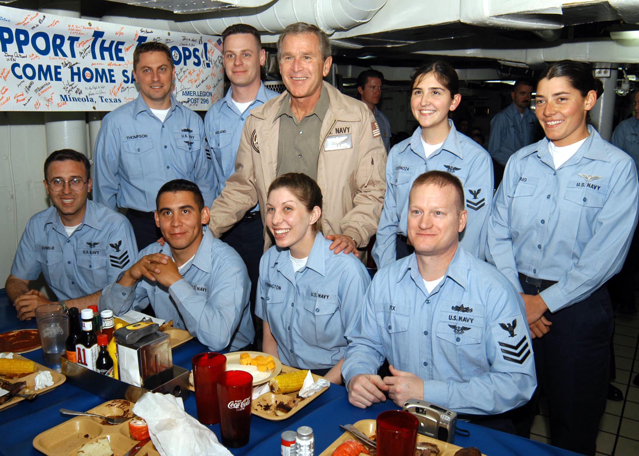 US Navy 030501-N-0000C-002 Aviation Ordnanceman Airman Timothy Roberts (seated, center left) who shares Midland, Texas, as a hometown with President George Bush, poses for a picture with the President