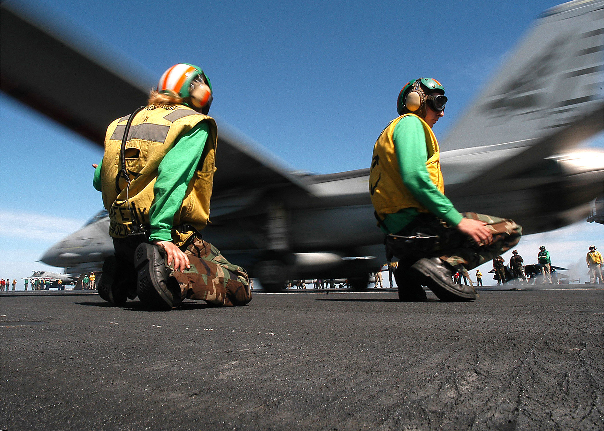 US Navy 040217-N-3986D-020 Flight deck catapult crew members work the ship^rsquo,s flight deck as an F-14B Tomcat s launched from the flight deck