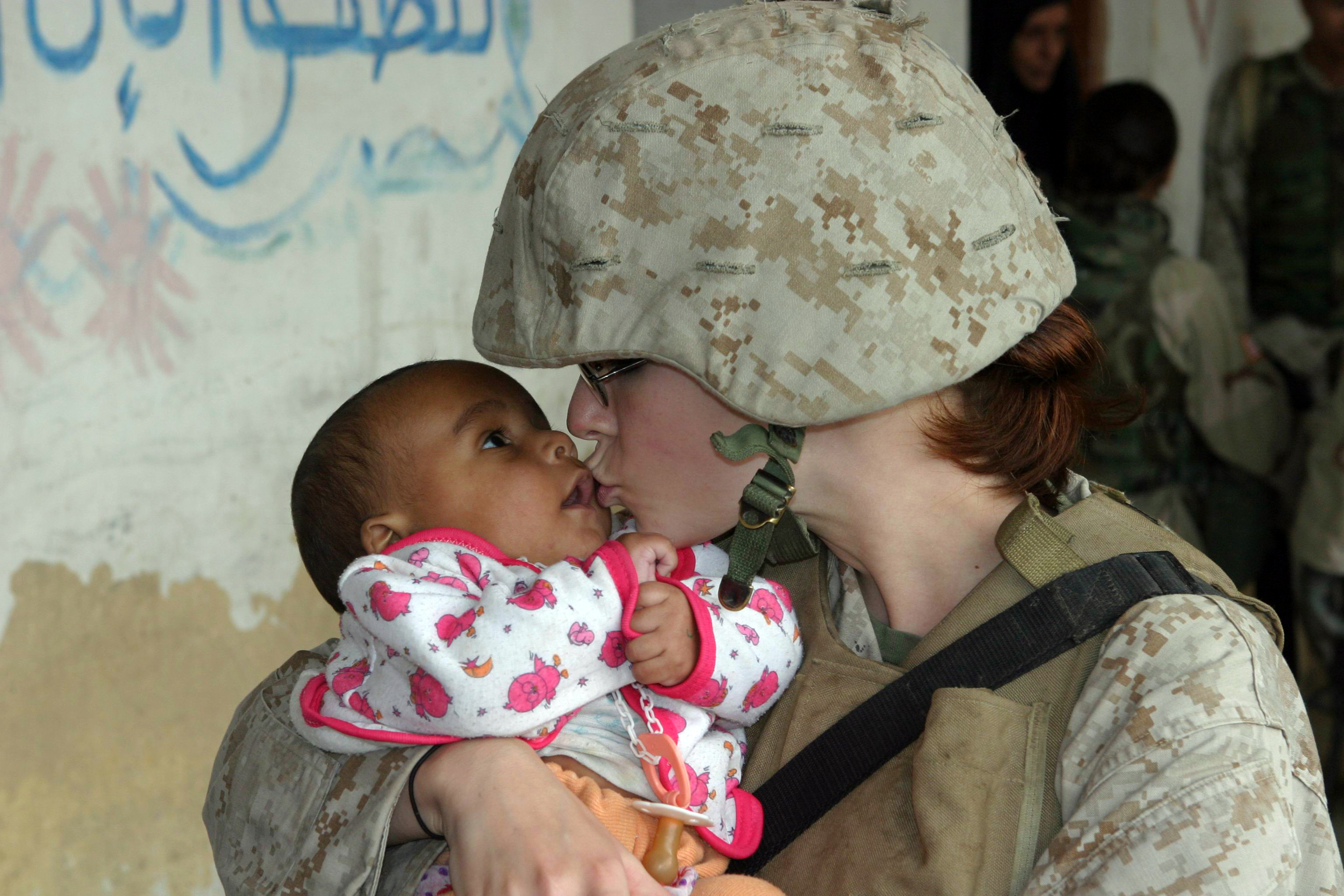 US Navy 041112-M-0095Z-181 Lance Cpl. Brandy L. Guerrero gives a kiss to an Iraqi baby waiting to be examined during a Humanitarian Assistance Operation (HAO) in the village of Ash Shafiyah, Iraq