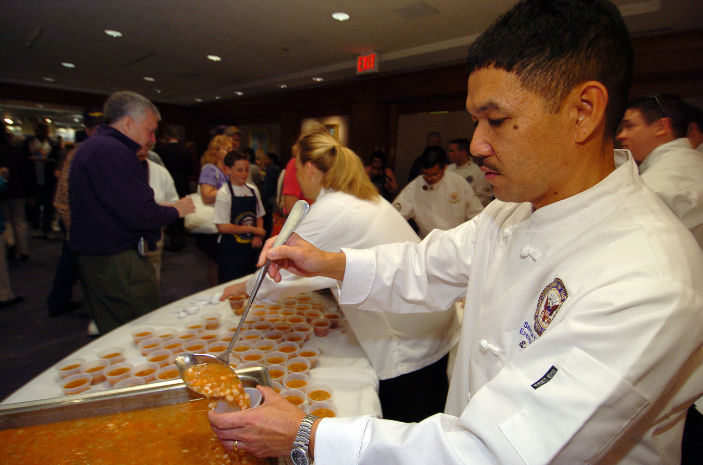 US Navy 050409-N-9693M-436 White House Chef Culinary Specialist 1st Class Ernesto Alvarez serves Navy Bean soup to visitors at the Navy Memorial